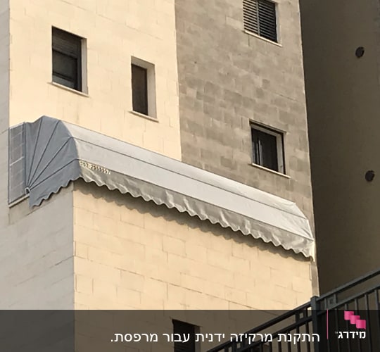 סוכך אפור מותקן על קיר בניין
